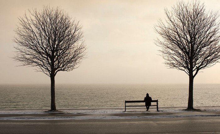 Mand sidder alene på bænk - sjælesorg
